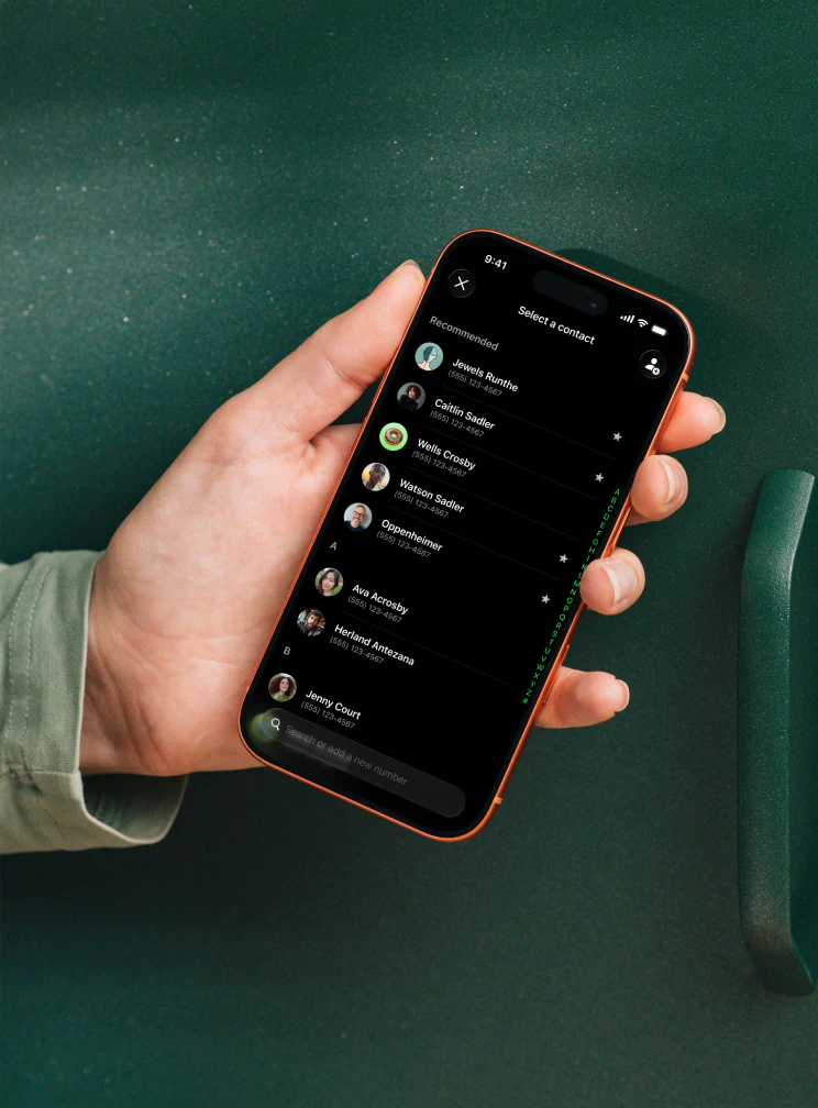 A hand holding a phone with the contact picker open, showing suggested contacts and a search field.